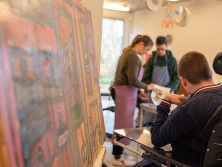 groepje is aan het schilderen naast schilderij